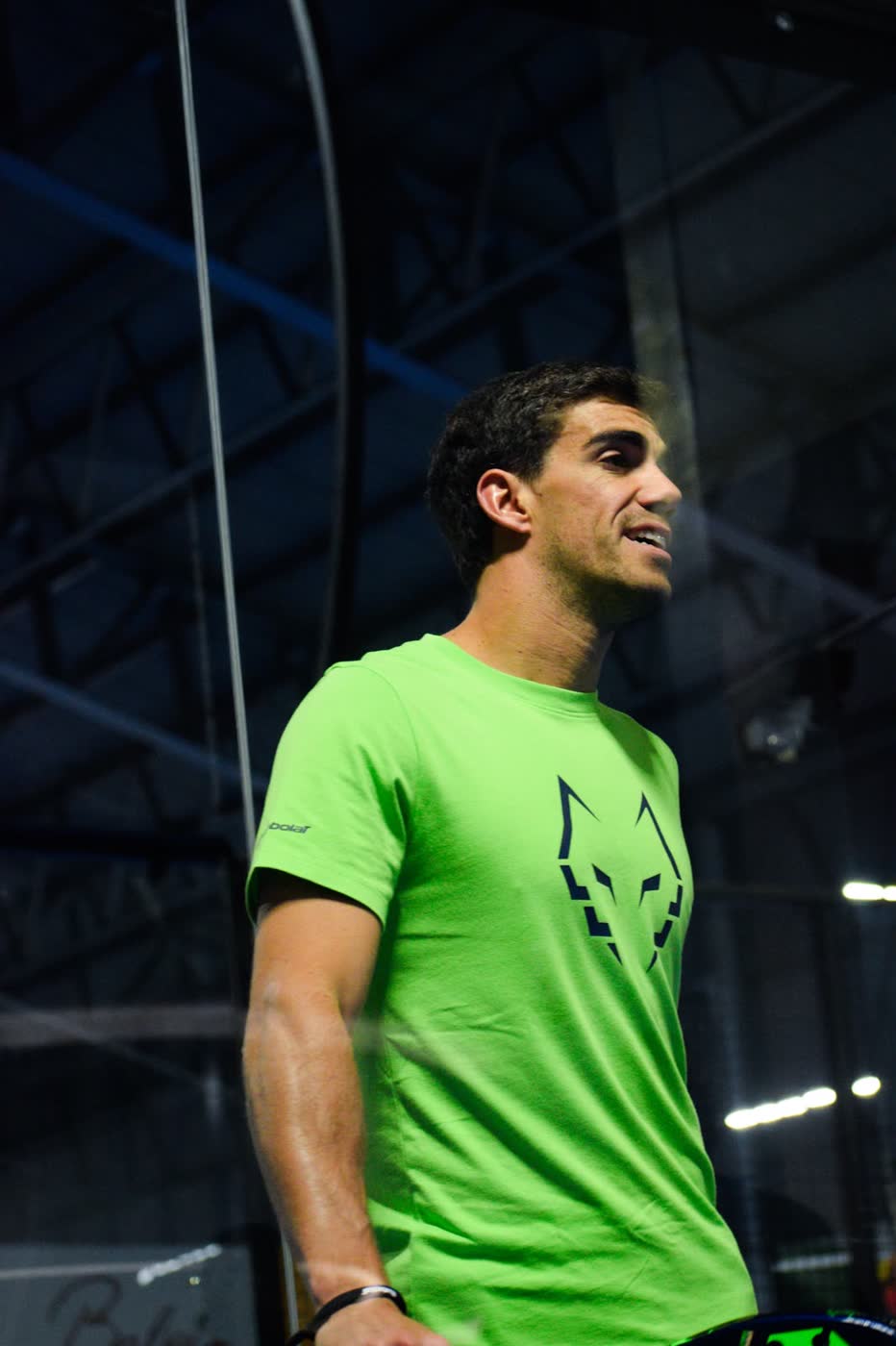 Portrait of padel player Juan Lebrón Chincoa in a green shirt looking off court between points